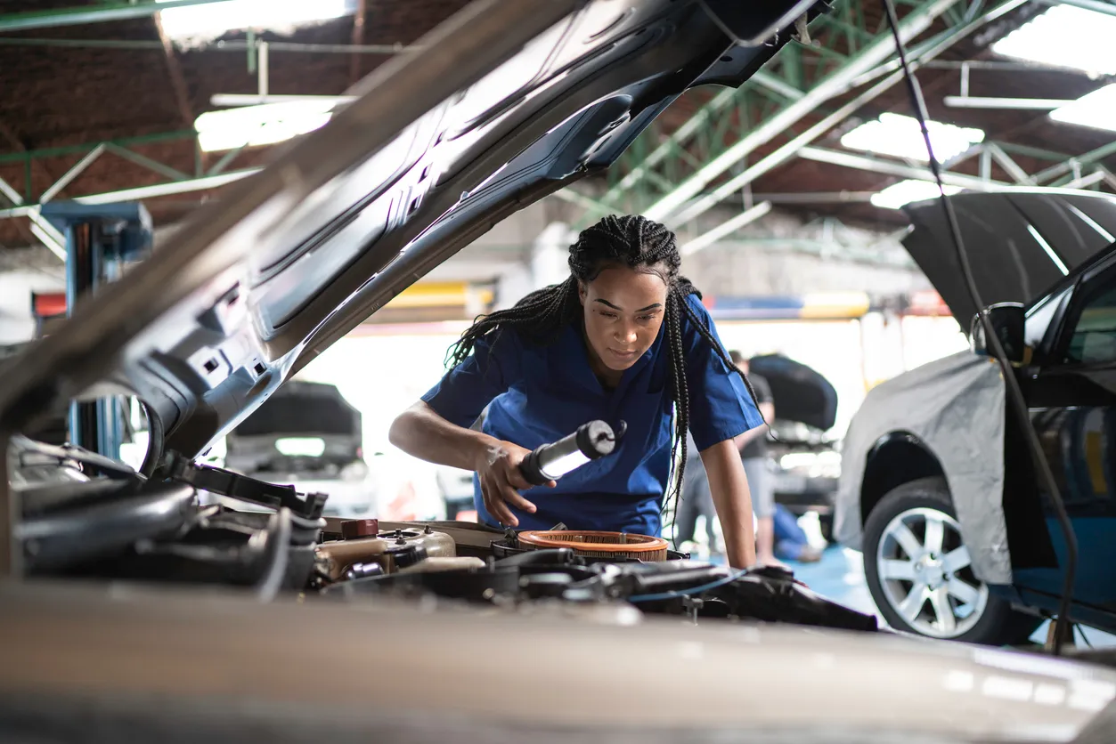lady examining car in workshop